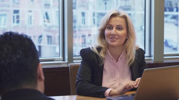 Business Woman Sitting at the Laptop and Negotiating with Her Business Partner