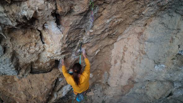 Top View Cinematic Slow Motion of Strong Skilful Man Rock Climber Climbs on Overhanging Rock Cliff