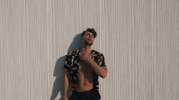 Muscular Man in a Shirt Posing Against a Wall