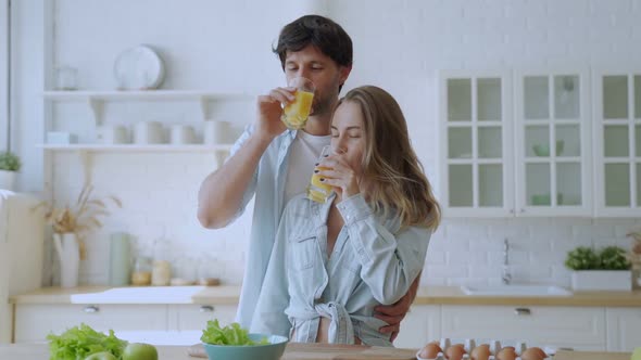 Happy Couple Drinking Orange Juice at Kitchen