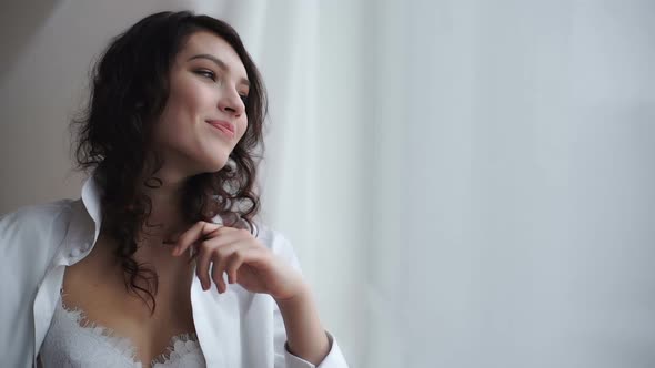 The Girl Smiles Near a Window