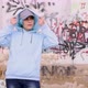 Blue haired teenage girl wearing light blue hoodie and stays against graffiti wall - VideoHive Item for Sale