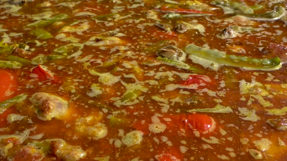 A close up shot of a Spanish Paella being cooked, panning from right to left, slow motion