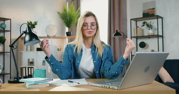 Blond Woman in Glasses Meditating with Closed Eyes Making Break in Her Work on Laptop