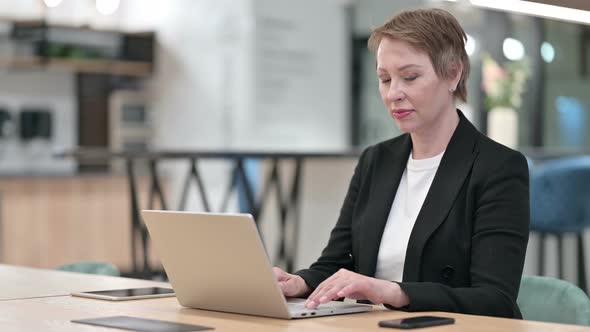 Old Businesswoman with Laptop Saying No By Finger Sign 