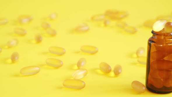 Omega 3 Capsules in Glass Jar on Yellow Background