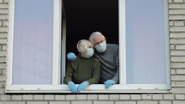 Old Grandparents Stay at Window Isolated at Home on Quarantine. Coronavirus