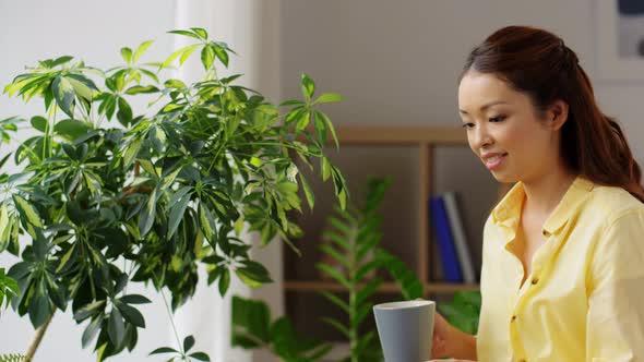 Happy Smiling Asian Woman Drinking Coffee at Home