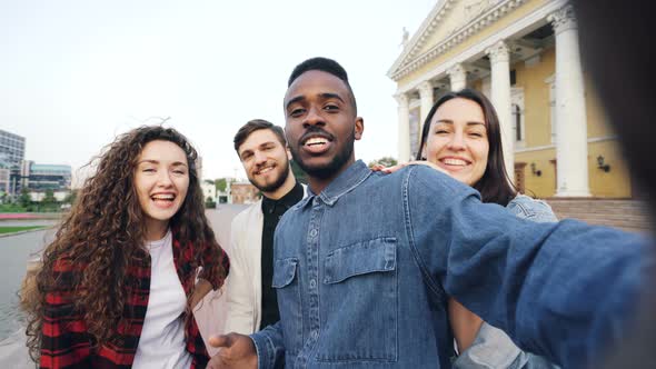 Point of View Shot of Happy Friends Tourists Making Online Video Call Holding Device, Looking at