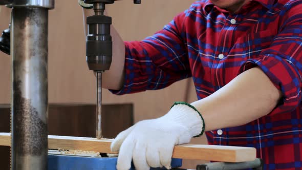 Close up of Carpenter Hand drilling wood by drilling  machine in workshop