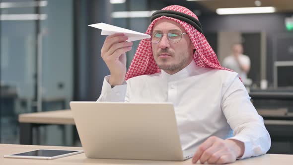 Middle Aged Arab Man with Laptop Flying Paper Plane