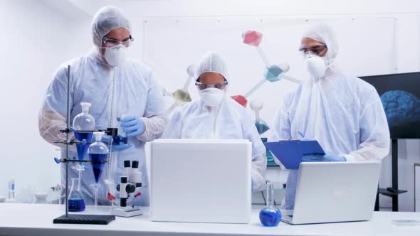 Team of Researcher in Coverall Equipment Taking Out Virus From a Refrigerator Box alt