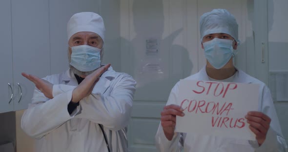 Two Doctors Show Stopgesture and Inscription "Stop Coronavirus" in Hospital