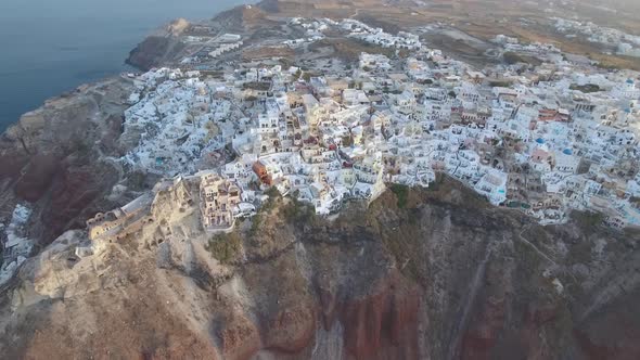 Flying over beautiful and famous Oia on Santorini Island in Greece during sunrise