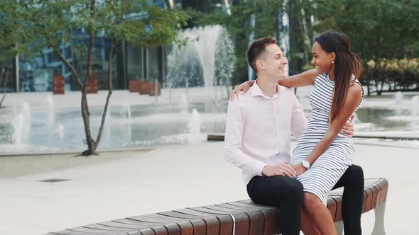 Romantic Multiracial Couple Having a Date Woman Whispering Something in Boyfriend's Ear