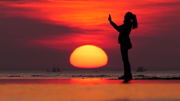 Woman say good bye and go away, silhouetted shot at sea beach, telephoto view