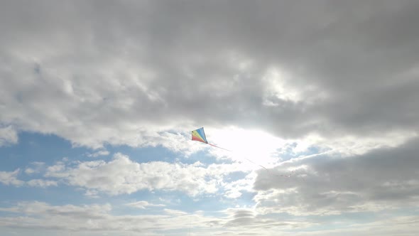 One young and beautiful woman playing with a flying kite in the sky - freedom concept and lifestyle