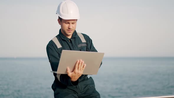 Concentrated Port Inspector Supervisor Working on Laptop Computer in Ship Terminal