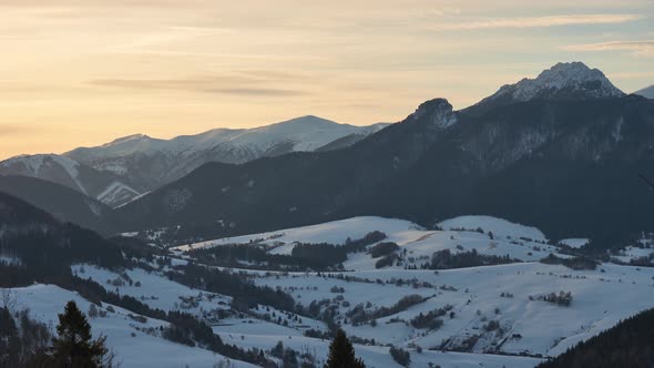 Winter Rural Landscape Under the Mountains at the End of the Day