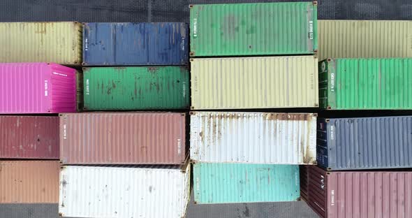 Top down view of colorful containers piles in port container terminal, industrial cargo harbor