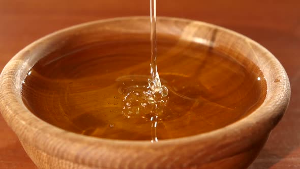 Taking Honey By Using Spoon in Wooden Bowl