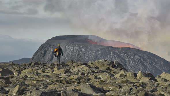 Man Walking Towards Erupting Fagradalsfjall Volcano In Reykjanes Peninsula