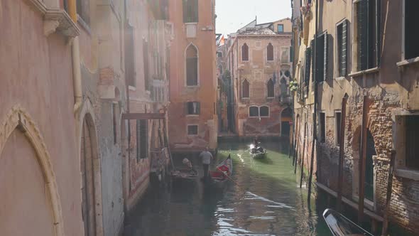 Gimbal Shot of Two Gondolas in Narrow Canal Among Old Houses