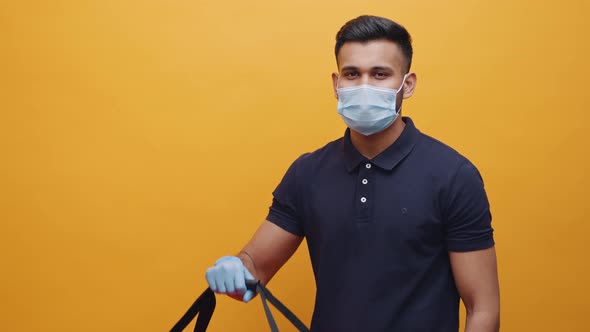 Young Man Lifting Food Delivery Bag and Showing Thumb Up