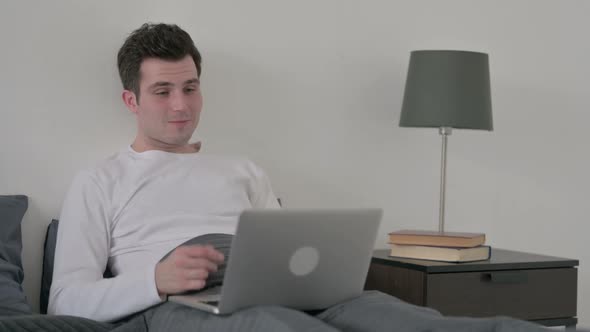 Man Doing Video Call on Laptop in Bed