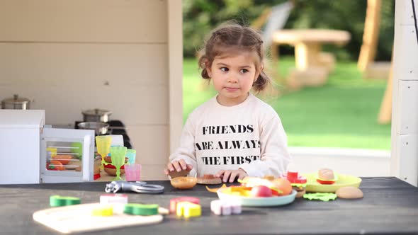 Happy Little Girl Playing on Toy Kitchen on Wheels