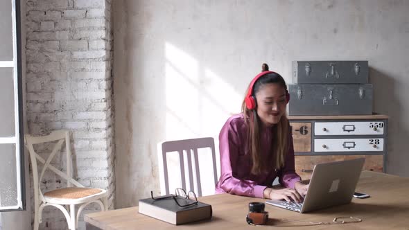 4k ultra hd young woman indoors listening music using computer