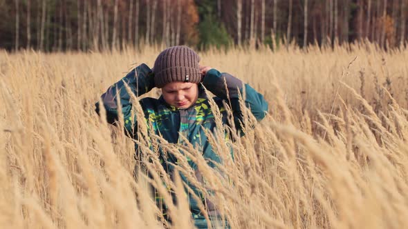 The Boy in the Tall Grass Looks at the Camera