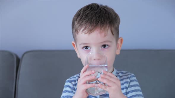 Portrait Funny Little Child Is Drinking a Cup of water.Cute Baby Boy Drinking a Glass of Water