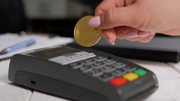 Closeup of a Woman Holding Bitcoin Near the Terminal on a White Background