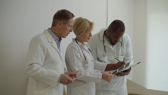 Group of Professional Multiethnic Medical Colleagues Reviewing Ultrasound Scan Results Indoors