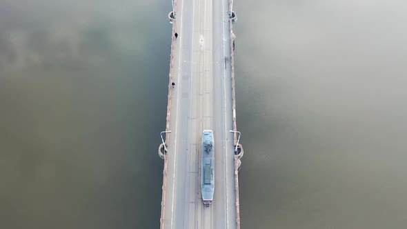 Birdseye Aerial View of Tram Moving on River Bridge With Sky Mirror Reflection. Prague, Czech Republ