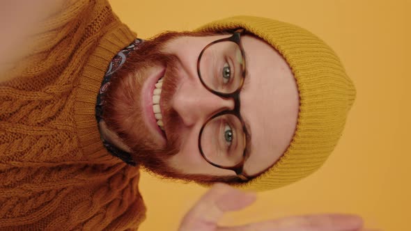 Close Up Young Bearded Caucasian Man Waves His Hand to the Camera Smiles Talks and Points His Finger