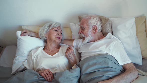 Old couple waking up in the morning.