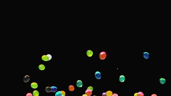 Bright Multicolored Water Gel Balls Bouncing Against a Black Background