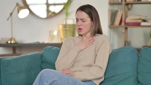 Sick Young Woman Coughing on Sofa