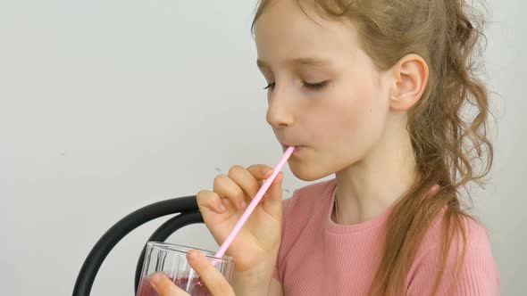 Sweet Little Girl Drinks Raspberry Smoothie and Smiles