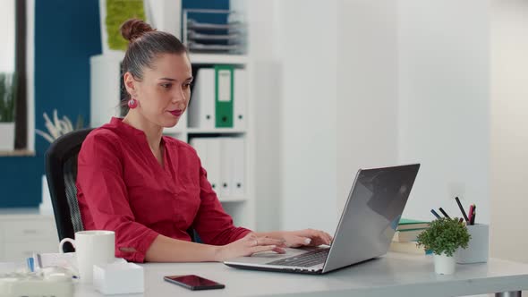 Company Employee Working on Business Project and Looking at Smartphone