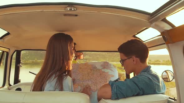 Friends Using Map Traveling In Car In Summer. Handsome Man And Beautiful Woman.