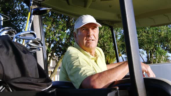 Golfer sitting in golf buggy