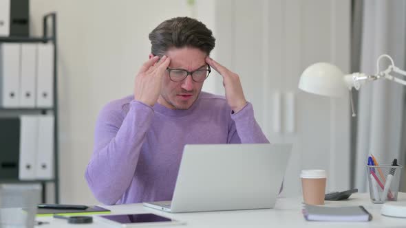 Middle Aged Man Having Headache in Office