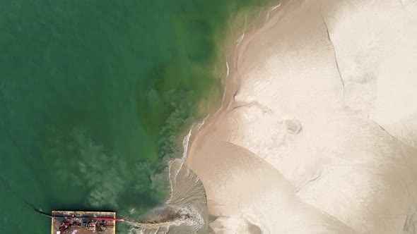 Curving around the peninsula of sand in bird's eye.
