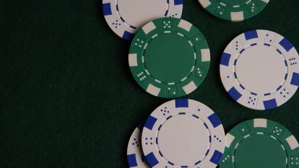 Rotating shot of poker cards and poker chips on a green felt surface - POKER 041