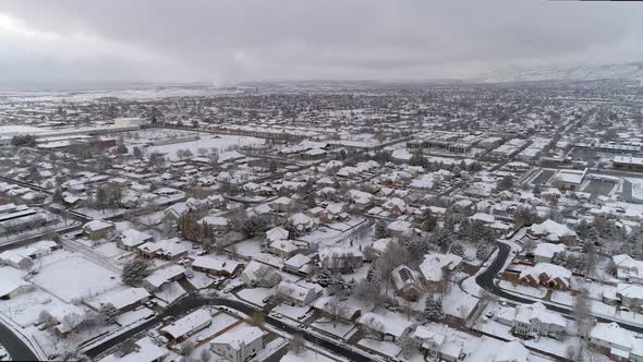 Aerial view flying over snow covered houses