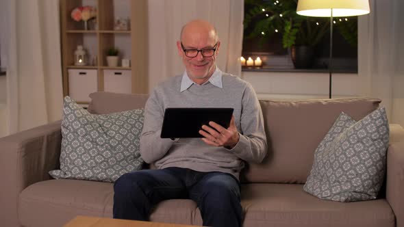 Happy Senior Man with Tablet Computer at Home