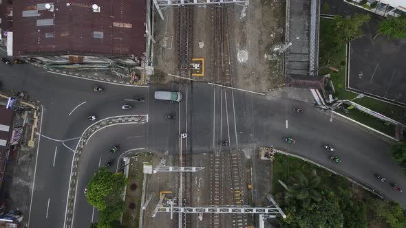 aerial view, smooth traffic of motorbikes and cars passing the railroad crossing near Lempuyangan st